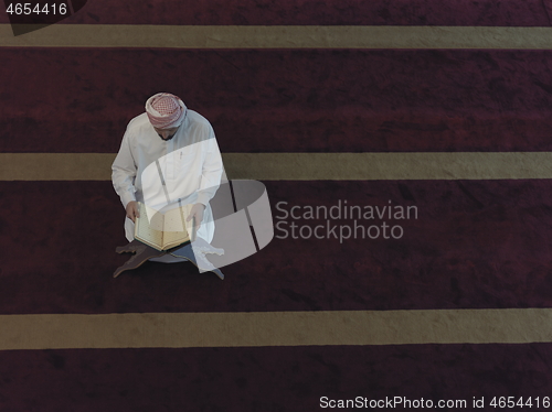 Image of muslim man praying inside the mosque top view