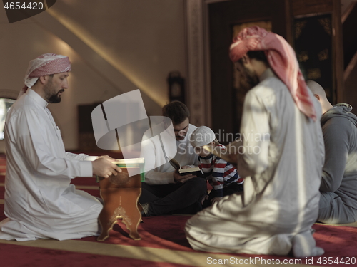 Image of muslim people in mosque reading quran together