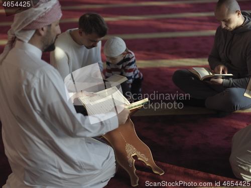 Image of muslim people in mosque reading quran together