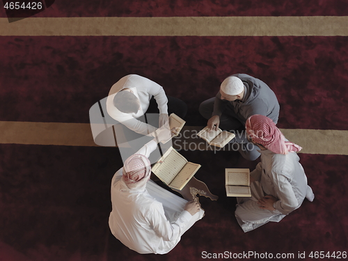 Image of top view of muslim people in mosque reading quran together