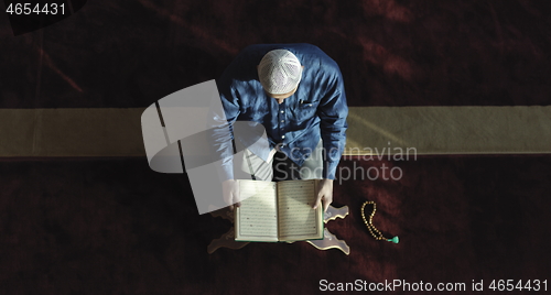 Image of muslim man praying inside the mosque top view