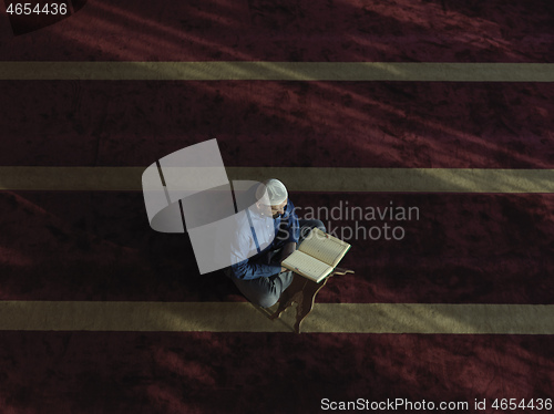 Image of muslim man praying inside the mosque top view