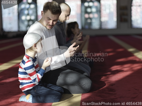 Image of father and son in mosque praying