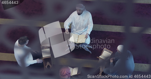 Image of top view of muslim people in mosque reading quran together