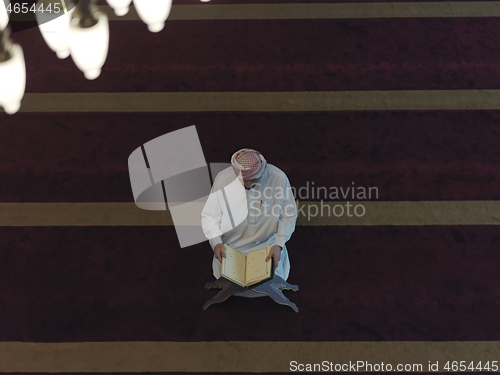 Image of muslim man praying inside the mosque top view