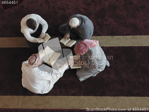 Image of top view of muslim people in mosque reading quran together