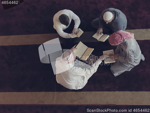 Image of top view of muslim people in mosque reading quran together