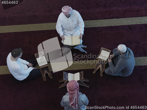 Image of top view of muslim people in mosque reading quran together