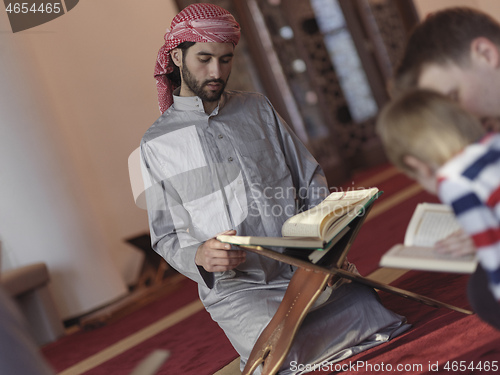 Image of muslim people in mosque reading quran together