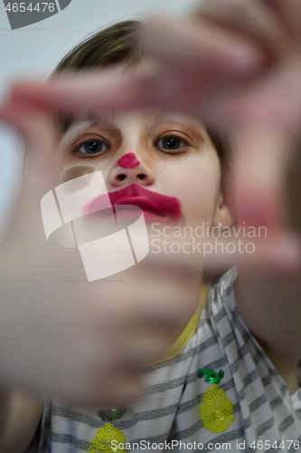 Image of Little girl playing with mommy\'s make up