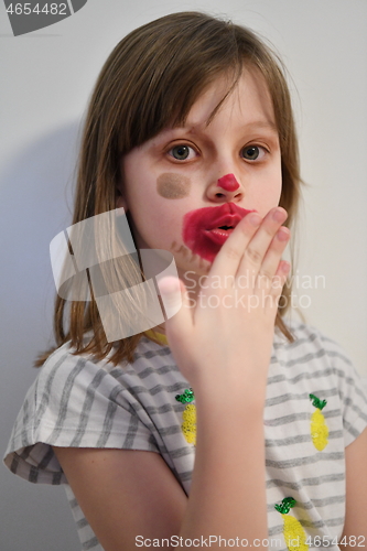 Image of Little girl playing with mommy\'s make up