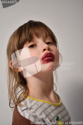 Image of Little girl playing with mommy\'s make up
