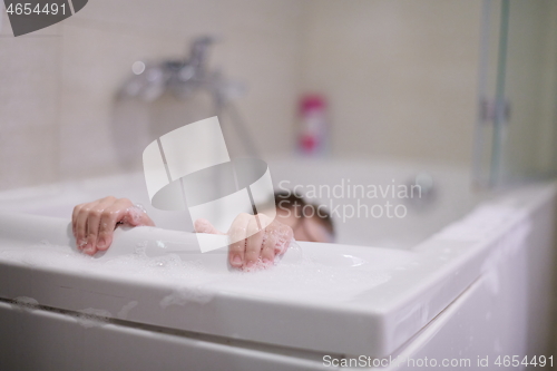 Image of little girl in bath playing with soap foam