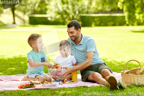 Image of happy family having picnic at summer park