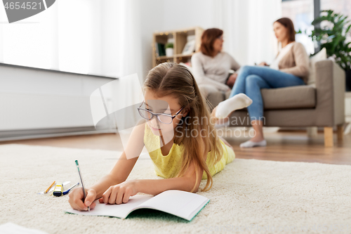 Image of student girl writing to notebook at home