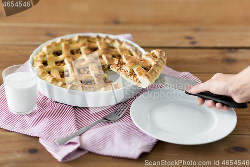 Image of close up of hand with piece of apple pie on knife