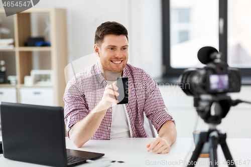 Image of male blogger with smartphone videoblogging