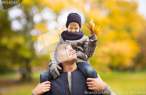 Image of happy family having fun in autumn park