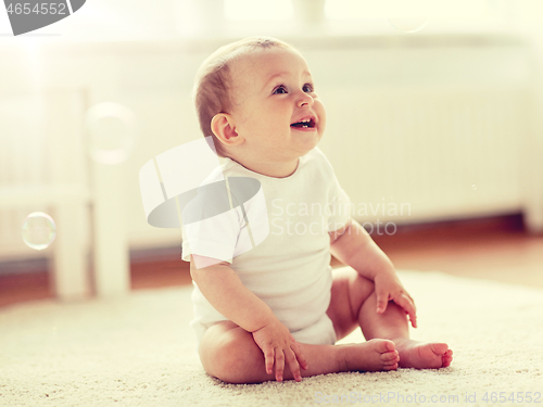 Image of happy baby with soap bubbles at home