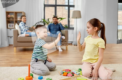 Image of brother and sister playing toy blocks at home