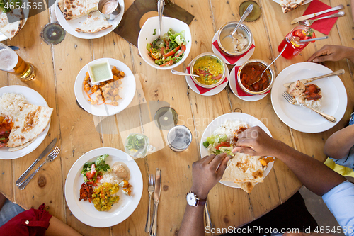 Image of african american friends eating at restaurant