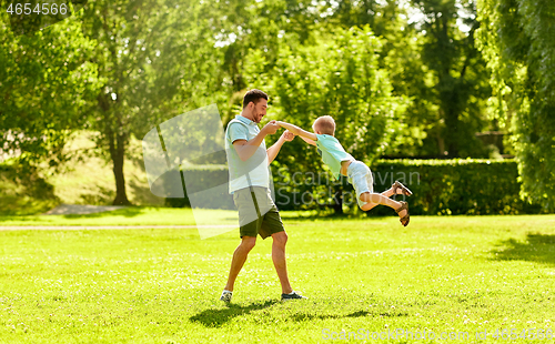 Image of happy father and son having fun at summer park