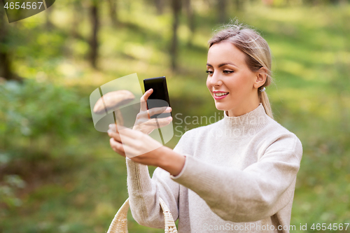 Image of woman using smartphone to identify mushroom