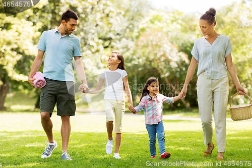 Image of family with picnic basket walking in summer park