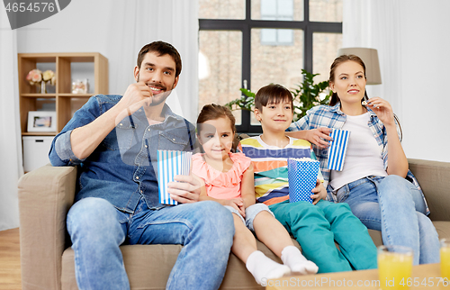 Image of happy family with popcorn watching tv at home