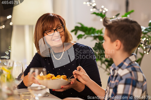 Image of grandmother and grandson having dinner at home