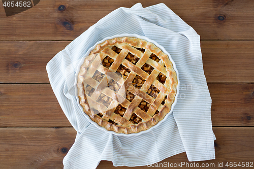 Image of close up of apple pie in mold on wooden table