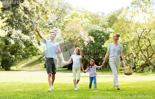 Image of family with picnic basket walking in summer park