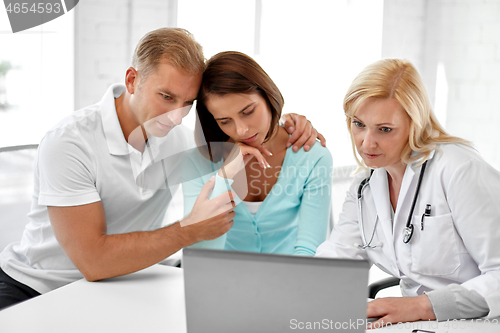 Image of sad couple and doctor at family planning clinic