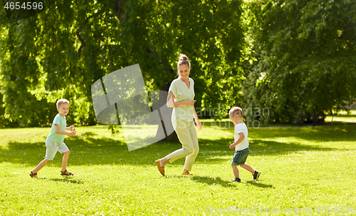 Image of mother with sons playing catch game at summer park