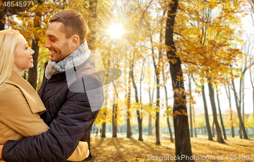 Image of smiling couple hugging in autumn park