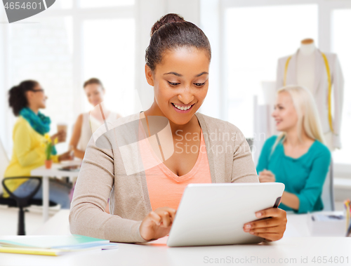 Image of fashion designer with tablet computer over studio