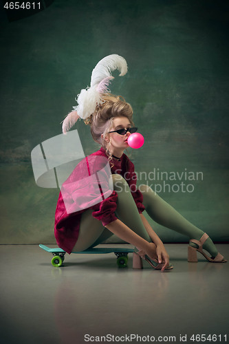 Image of Young woman as Marie Antoinette on dark background. Retro style, comparison of eras concept.