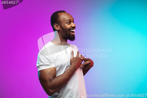 Image of African-american young man\'s portrait on gradient studio background in neon