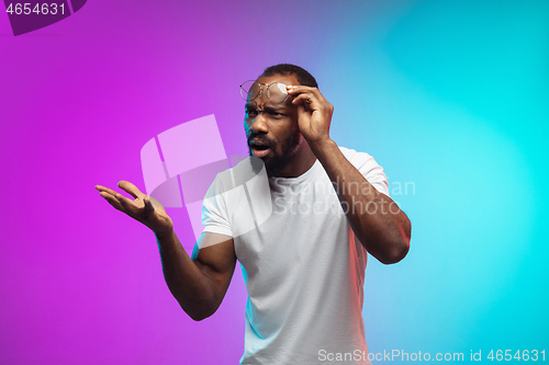 Image of African-american young man\'s portrait on gradient studio background in neon