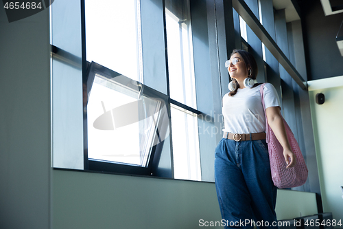Image of Young woman waiting for departure in airport, traveler with small baggage, influencer\'s lifestyle