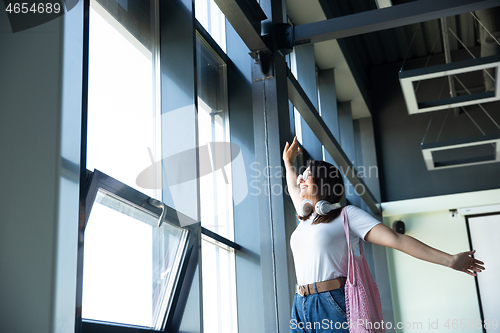 Image of Young woman waiting for departure in airport, traveler with small baggage, influencer\'s lifestyle