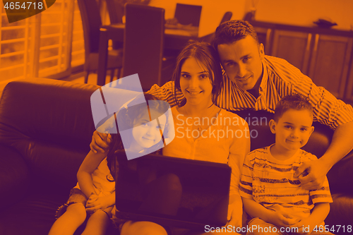 Image of happy young family have fun and working on laptop at home