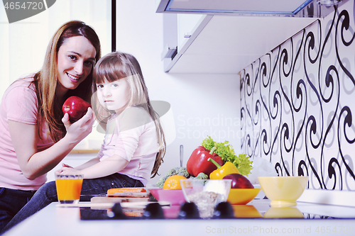 Image of happy daughter and mom in kitchen