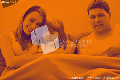 Image of happy family relaxing in bed