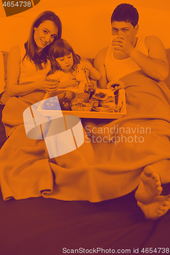 Image of happy young family eat breakfast in bed