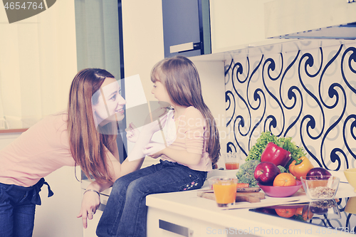 Image of happy daughter and mom in kitchen