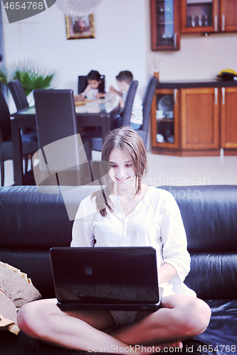 Image of happy young family have fun and working on laptop at home