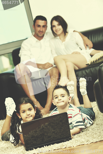 Image of happy young family have fun and working on laptop at home