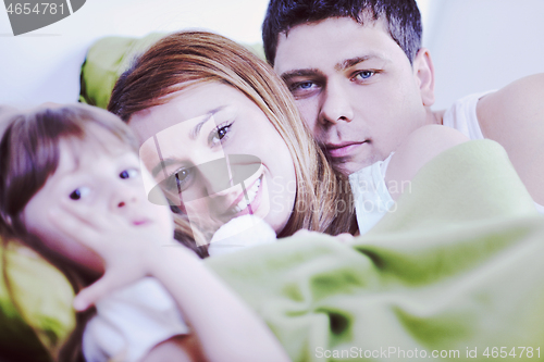 Image of happy family relaxing in bed