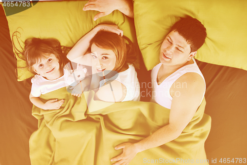 Image of happy family relaxing in bed